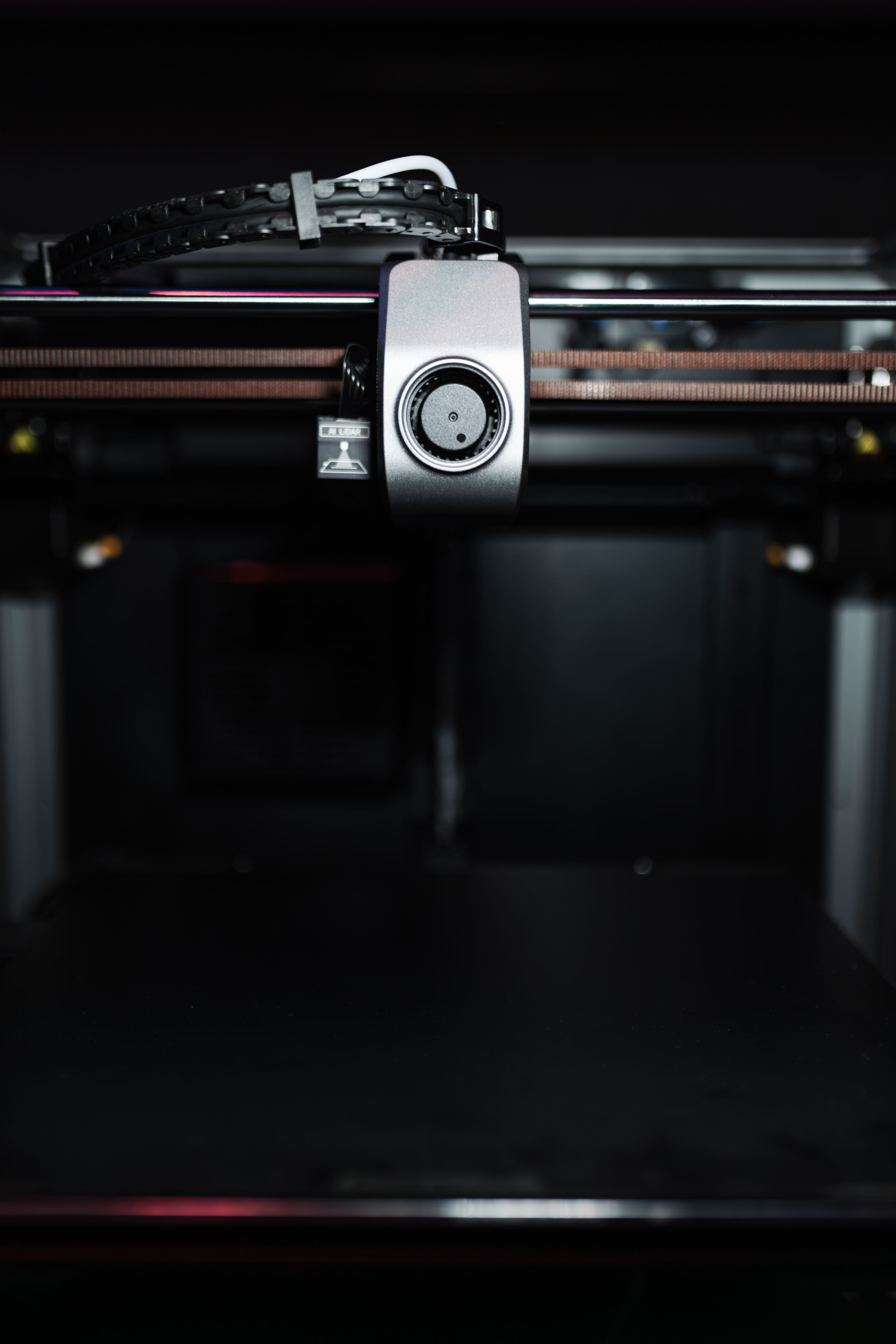 Close-up of a 3D printer nozzle laying down a print